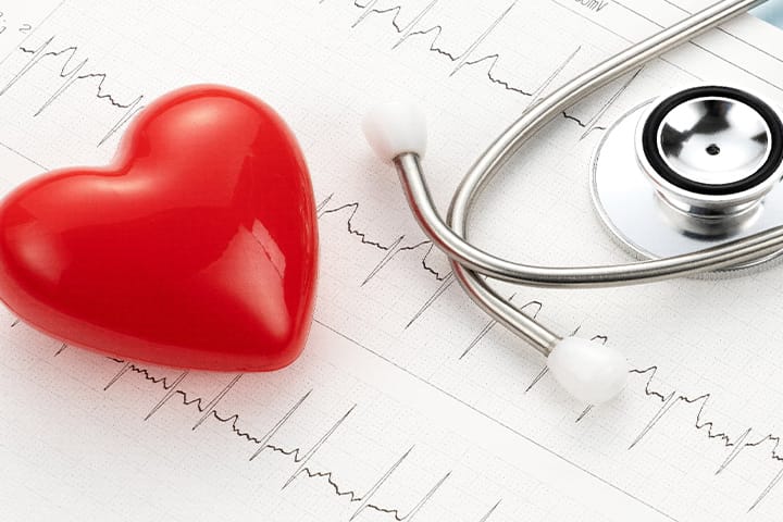 心電図用紙の上の聴診器とハート