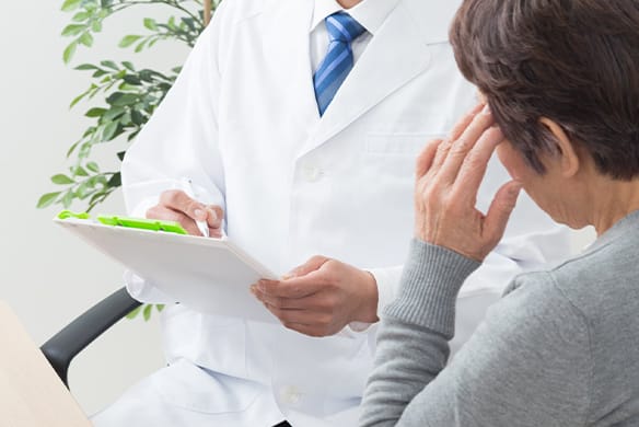 頭の痛みを訴える患者に問診する医師